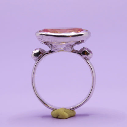 Silver ring with a large peach stone on a purple background. New Zealand made jewellery designer