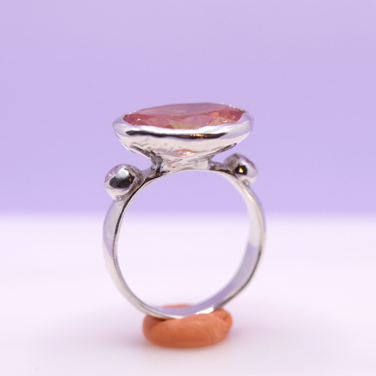 Silver ring with a peach gemstone on a white background. New Zealand made jewellery designer