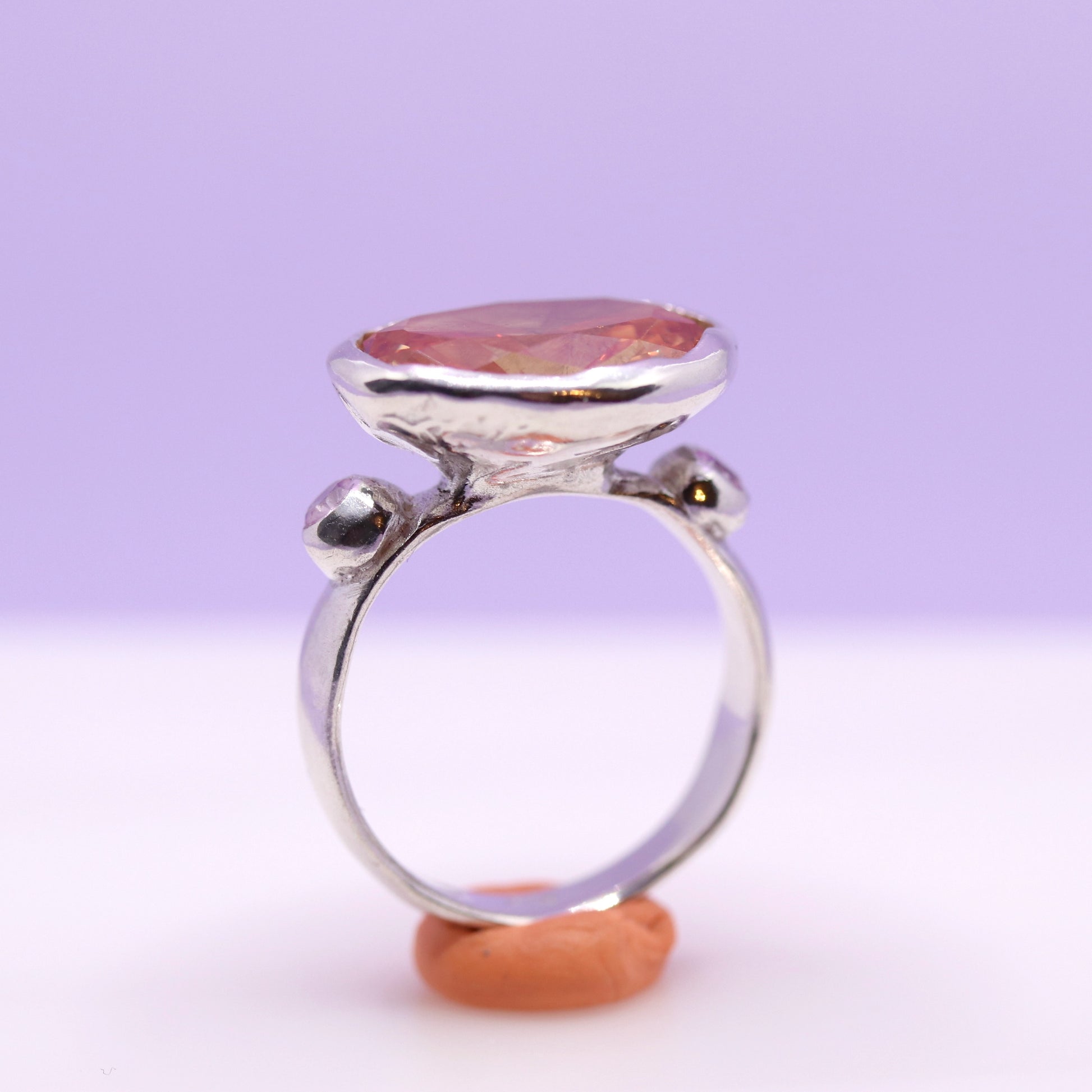 Silver ring with a peach gemstone on a white background. New Zealand made jewellery designer