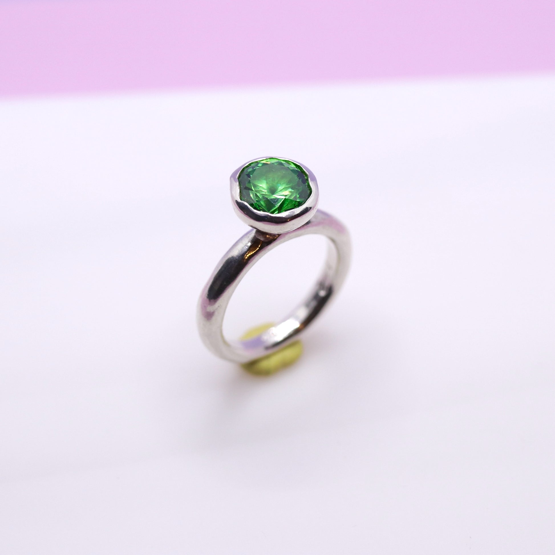 Silver ring with a tsavorite green gemstone on a white background. New Zealand made jewellery designer