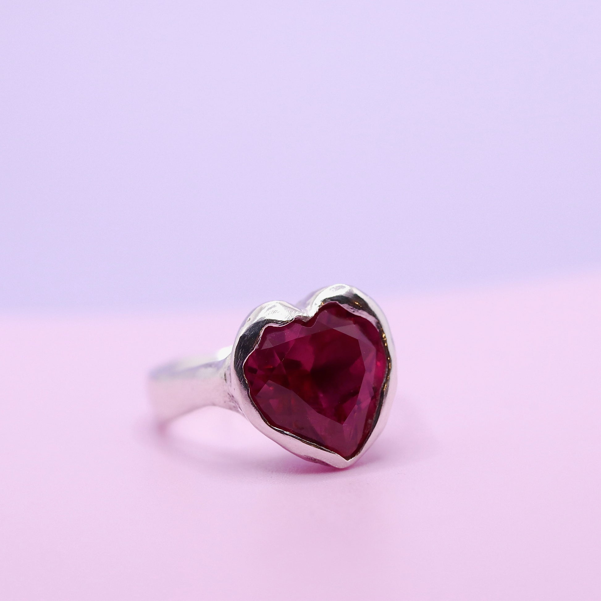 Heart-shaped red gemstone ring on a light purple background. New Zealand made jewellery designer