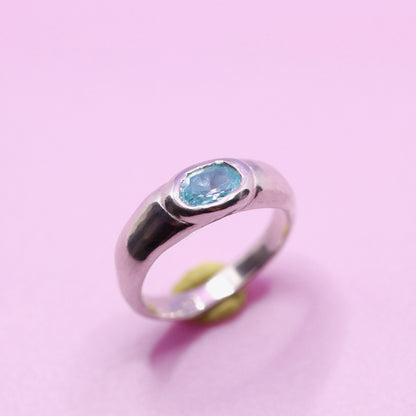 Silver ring with a aquamarine blue gemstone on a pink background. New Zealand made jewellery designer