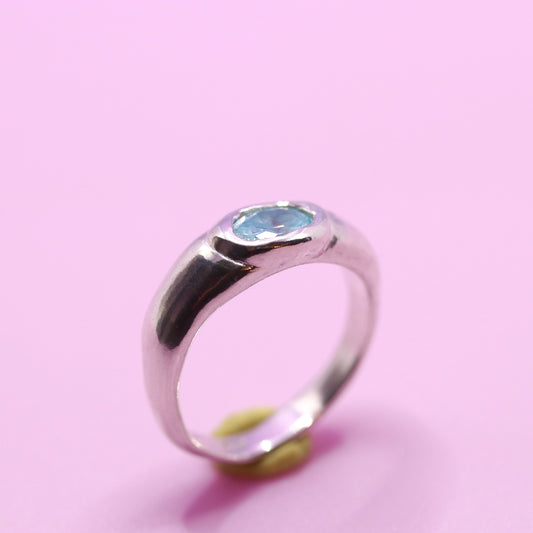 Silver ring with a blue gemstone on a pink background. New Zealand made jewellery designer