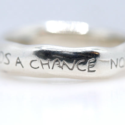 Silver ring with engraved text on a white background