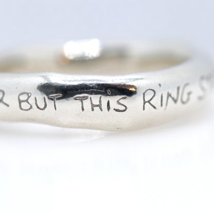 Silver ring with engraved text on a white background