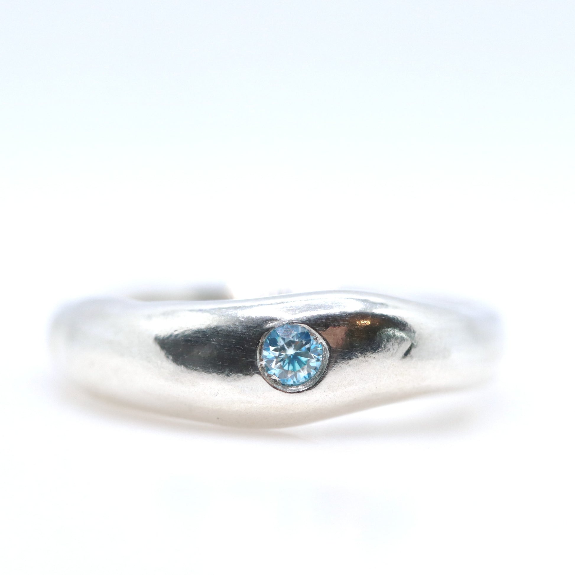 Silver ring with a blue gemstone on a white background