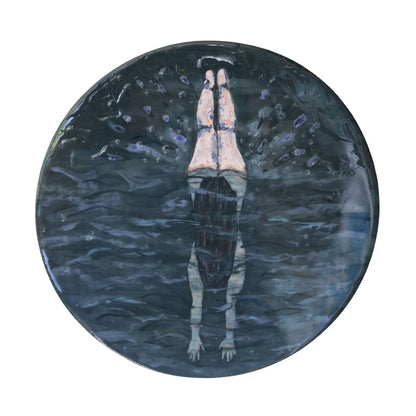 Round painting of woman diving below water surface with legs in the air