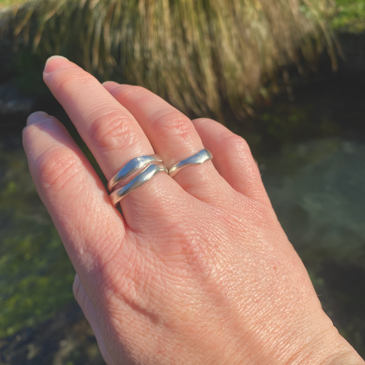 Waterworn silver rings worn by a Wānaka creek