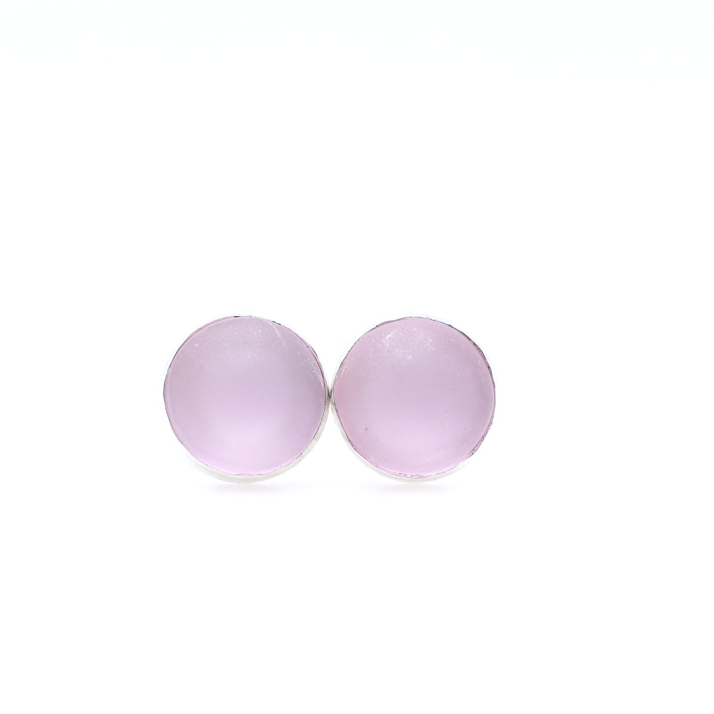 Pair of round pink earrings on a white background